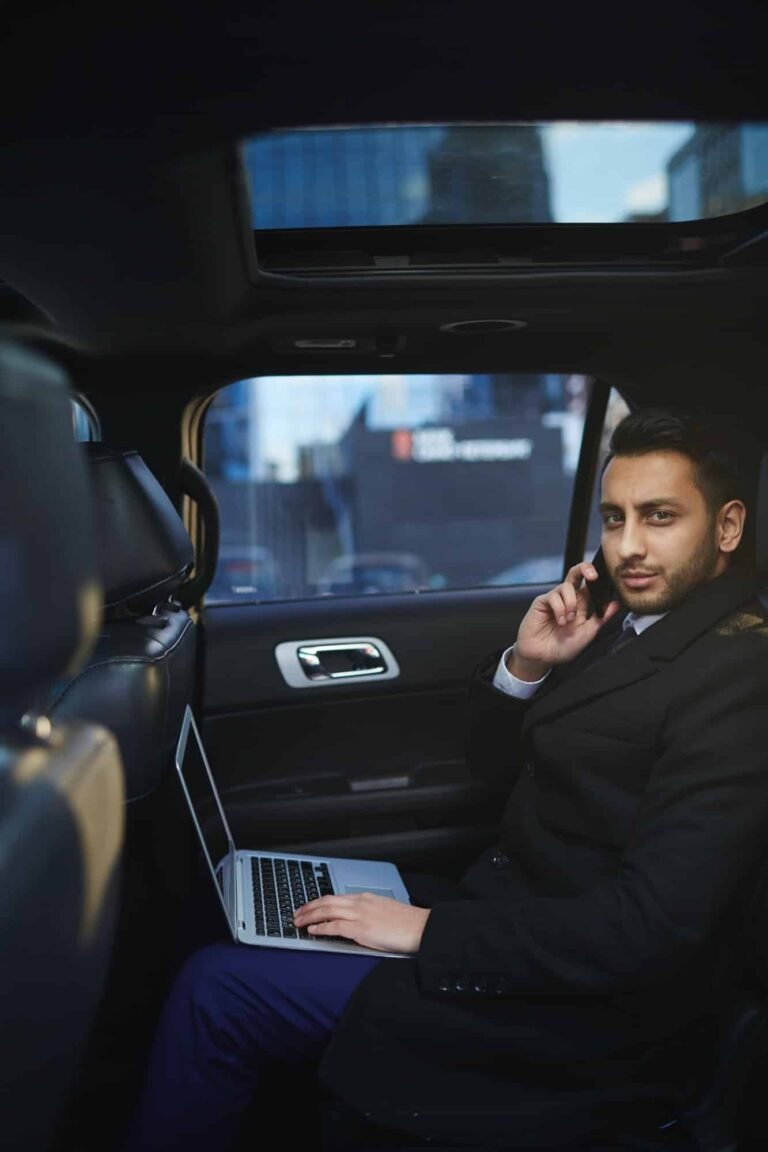 chauffeur privé au téléphone devant un ordinateur à Paris dans une voiture