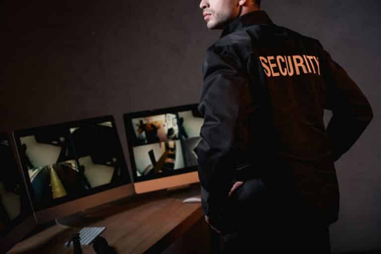 partial view of guard in black uniform at workplace